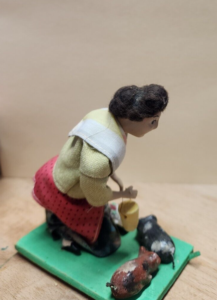 Vintage folk art doll feeding the pigs 4"